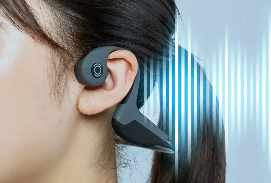 Person wearing bone conduction headphones to help deaf individuals hear vibrations through their cheekbones.
