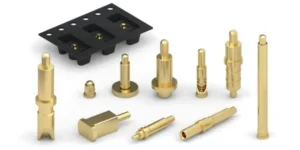 A product image showing a collection of gold-colored pogo pins, commonly used in earphone charging cases. The composition displays various individual pins of different shapes and sizes, a black plastic connector housing them, and one pin with its internal spring visible, highlighting the mechanics of these spring-loaded connectors.